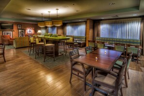A spacious hotel room with a wooden floor, a dining area with a pool table, a sofa, and a television on the wall. - Hampton Inn Goldsboro NC (Goldsboro)