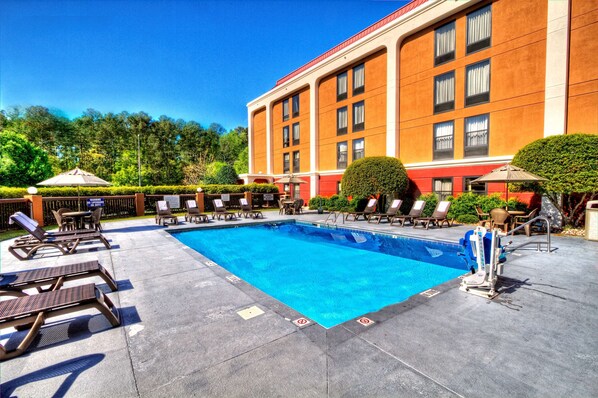 Relax by the pool surrounded by comfortable lounge chairs and umbrellas.