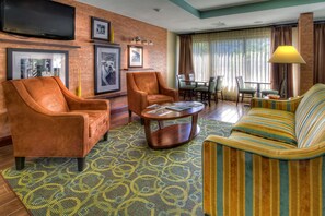 Relax in a spacious room with a seating area, flat-screen TV, and dining set.