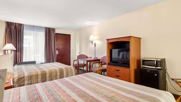 Habitación de hotel con dos camas, un escritorio, un televisor y un microondas.