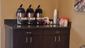 A kitchenette with a coffee maker, a kettle, and a hot water dispenser. There are also condiments and a coffee mug on the counter. - Red Roof Inn Elkhart (Elkhart)