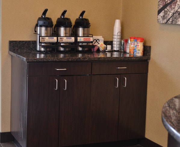A kitchenette with a coffee maker, a kettle, and a hot water dispenser. There are also condiments and a coffee mug on the counter. - Red Roof Inn Elkhart (Elkhart)