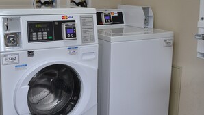 A front-loading washer and dryer unit with a digital display, payment card reader, and a control panel. - Red Roof Inn Elkhart (Elkhart)