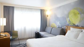 Une chambre d’hôtel comprenant un lit, un canapé, un bureau avec un ordinateur portable, une chaise et une fresque murale représentant la lune.