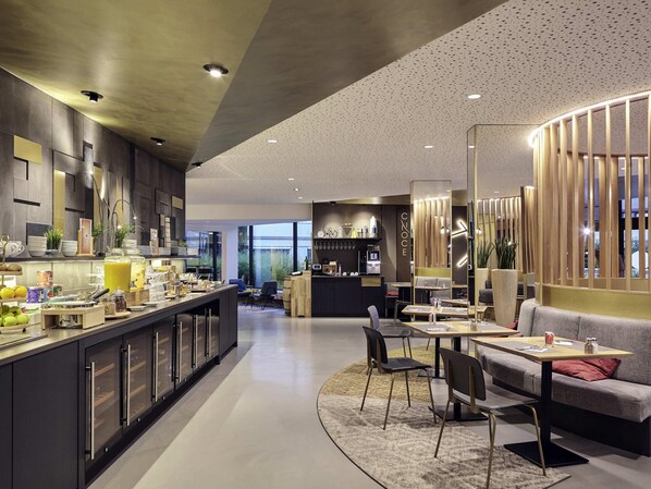 Eine moderne Hotelhalle mit Bar, Sitzgelegenheiten und Blick ins Freie.
