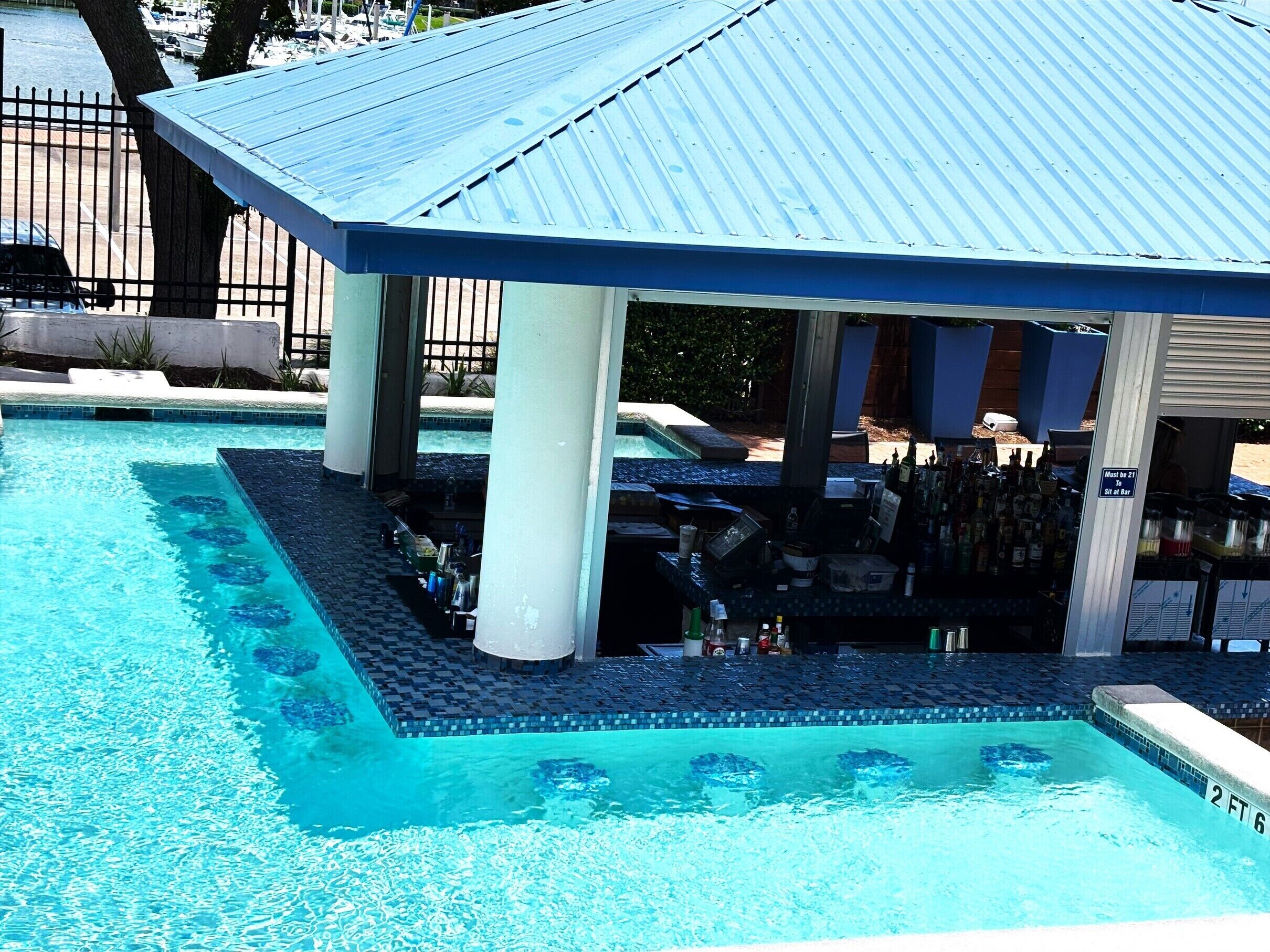 A pool area with a covered bar and lounge seating.