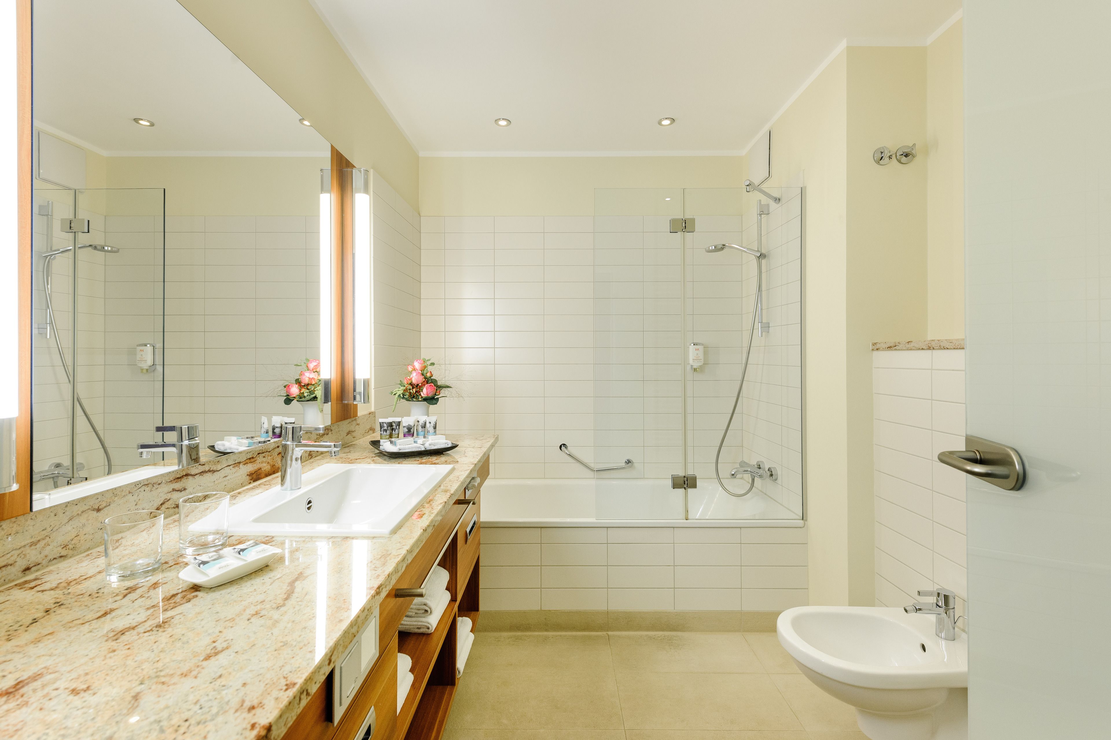 A modern bathroom with a double sink, a bathtub, and a shower.