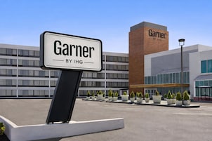 Placa de 'Garner by IHG' em frente a um edifício moderno com várias janelas e fachada de tijolos.