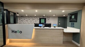 Un espace d’accueil avec une pancarte « Bonjour », un bureau avec des ordinateurs et une pancarte « MainStay Marketplace ».