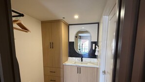 Une salle de bain avec un meuble-lavabo en bois, un miroir et un lavabo blanc.