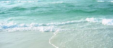 A beach with waves approaching the shore.