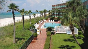 A hotel with a pool, beach view, and palm trees. - Casa Loma Inn (Panama City Beach)