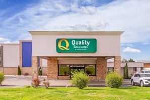 A hotel with a sign reading 'Quality Inn & Suites by Choice Hotels.'