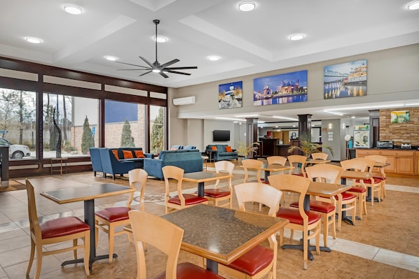 A hotel lobby with a seating area, a fireplace, and artwork on the walls. - Quality Inn & Suites Chattanooga-East Ridge (Chattanooga)