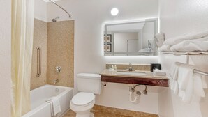 Une salle de bain équipée d’une baignoire, de toilettes, d’un meuble-lavabo et d’un porte-serviettes.