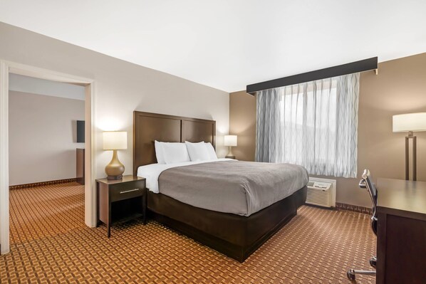 A hotel room with a large bed, bedside lamps, a desk, and a window with curtains. - Quality Inn & Suites Chattanooga-East Ridge (Chattanooga)