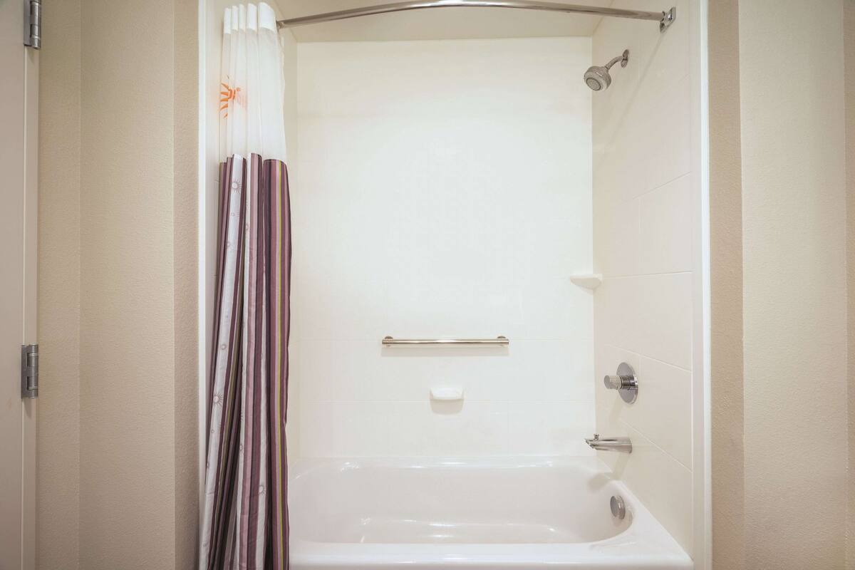 Une salle de bain avec une baignoire, une douche et des toilettes.