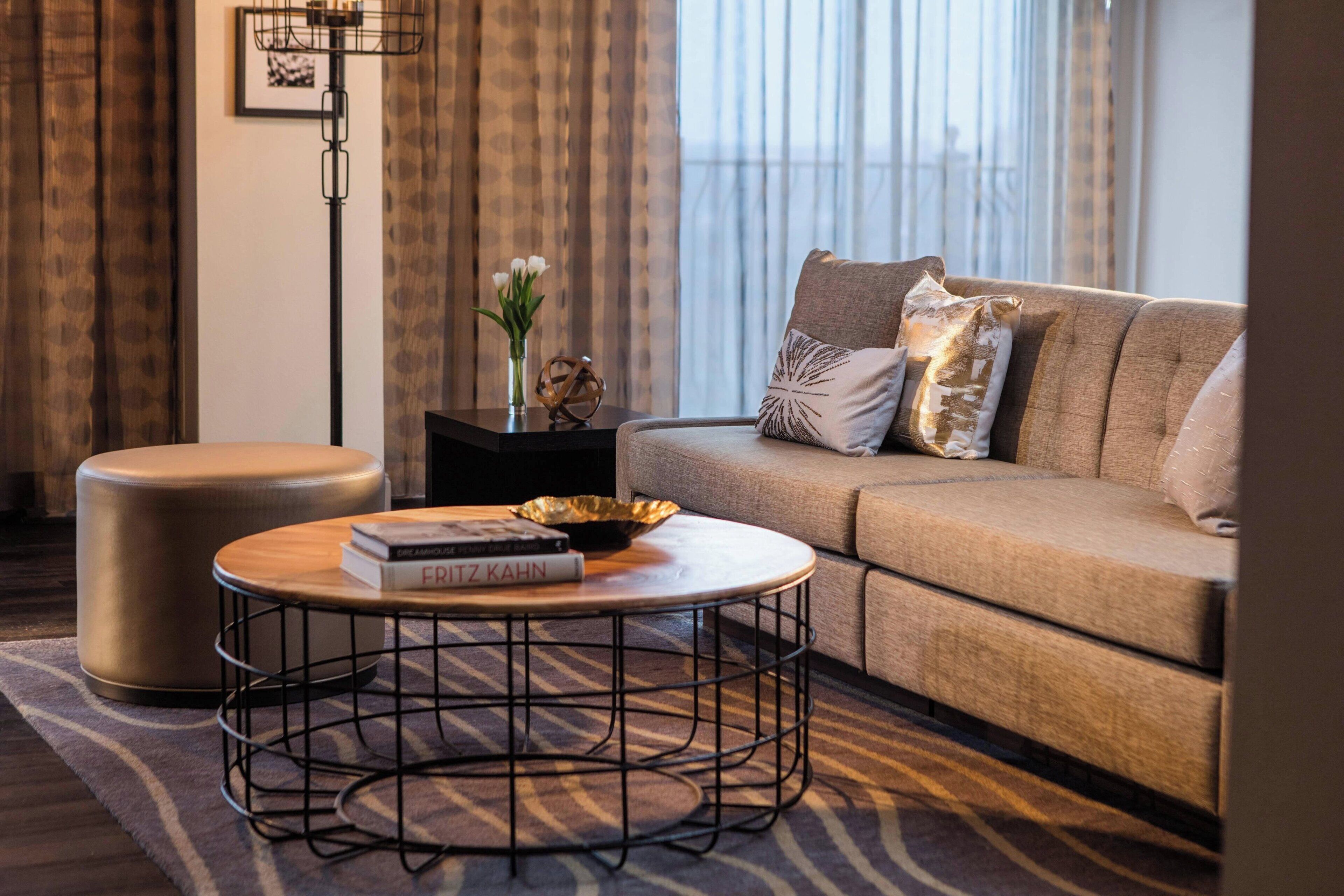 A modern living room with a sofa, a round coffee table, and a side table.