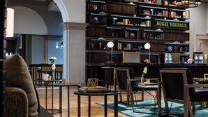 Eine Bibliothek mit Bücherregalen, einem Sofa und Tischen.