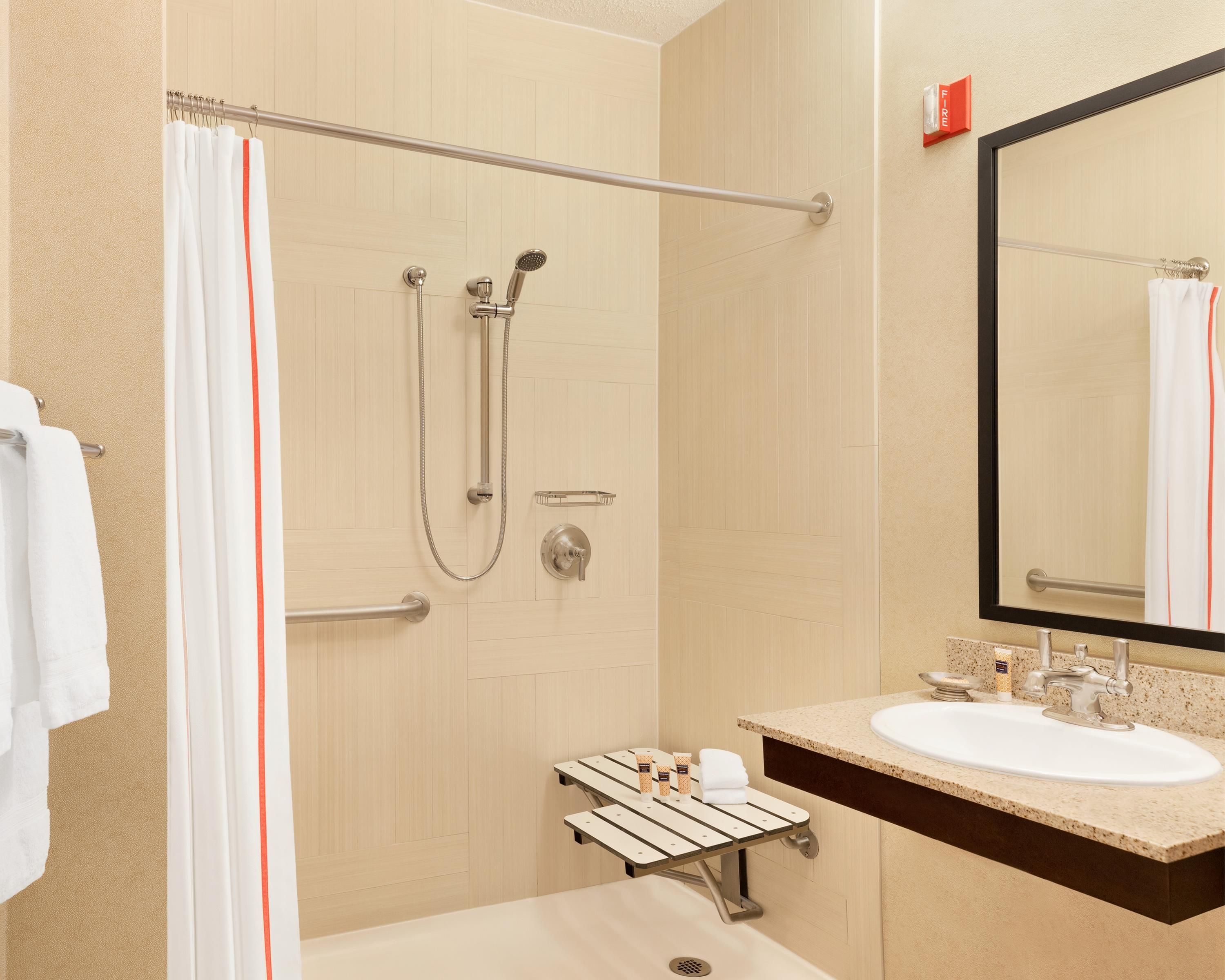Un baño moderno con ducha, lavabo y espejo.