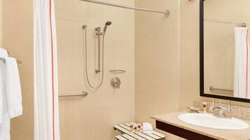 A modern bathroom with a shower, a sink, and a mirror.