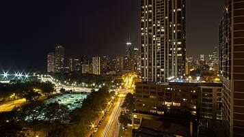 A nighttime cityscape with high-rise buildings, illuminated streets, and a river.