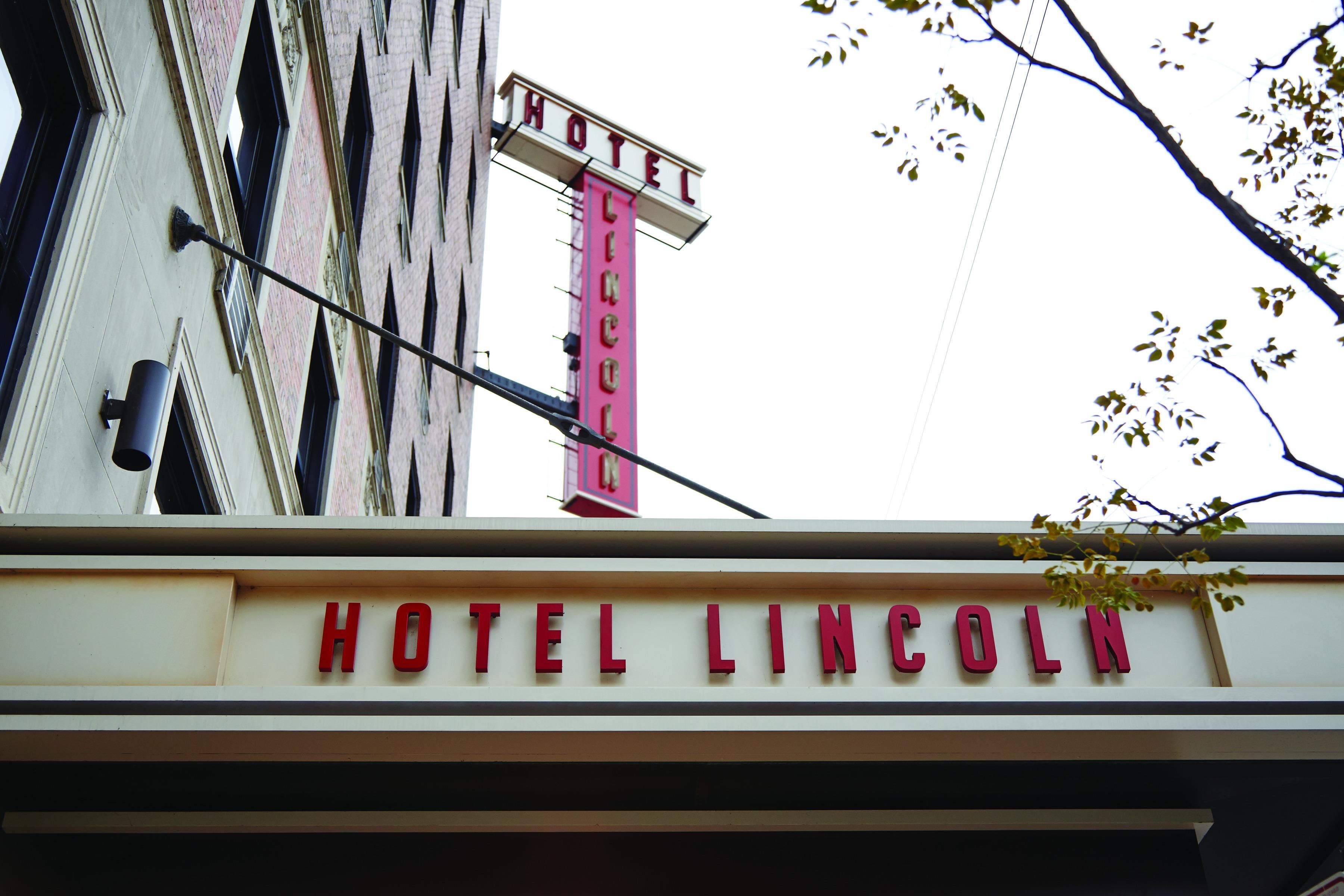 En bygning med et skilt, der siger 'HOTEL LINCOLN', og et rødt skilt over det, der står 'HOTEL'.