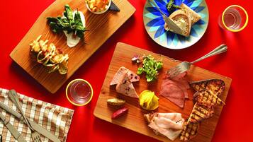 A wooden board with various food items including bread, meat, and vegetables.