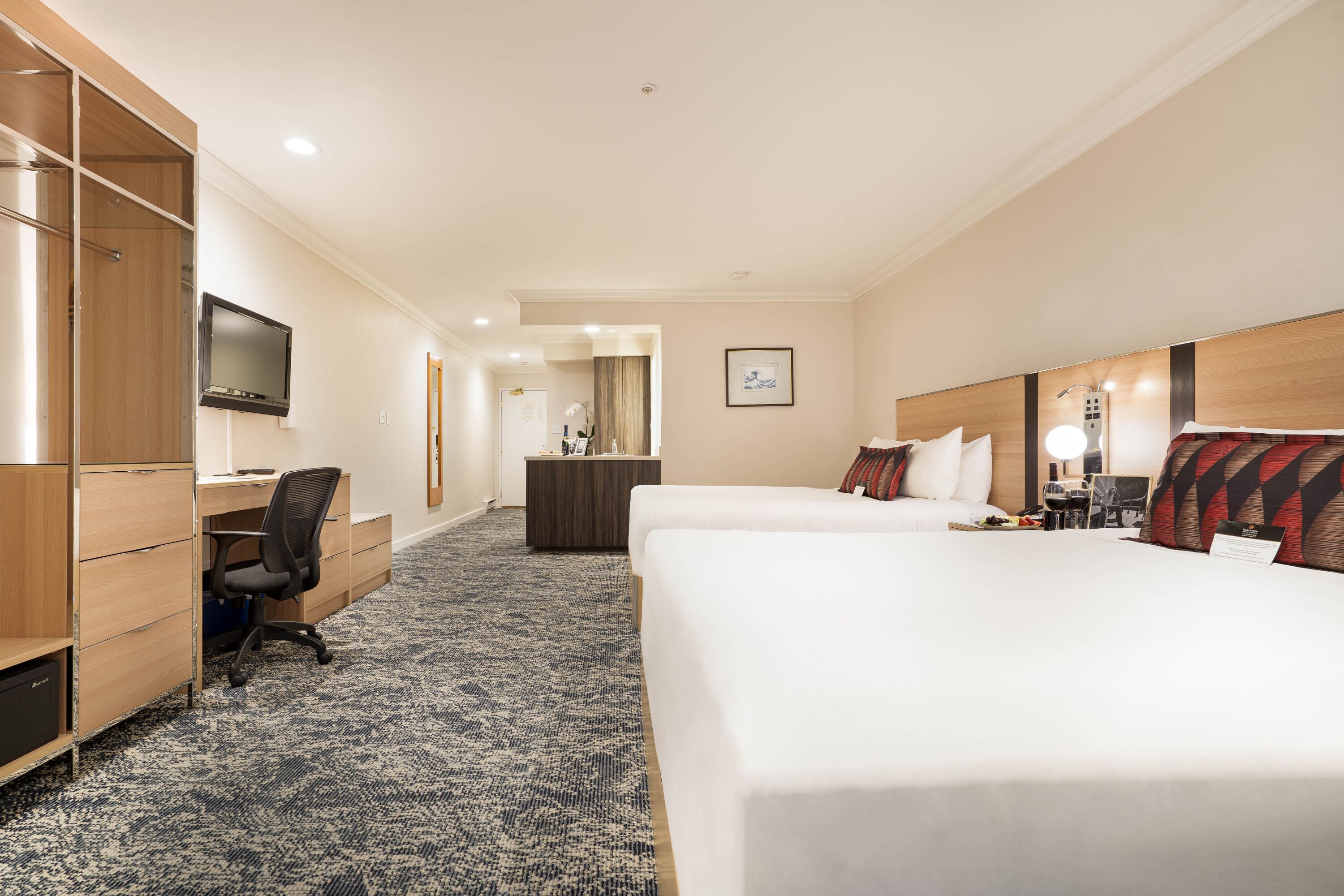 Une chambre d’hôtel équipée d’un lit, d’un bureau, d’une chaise, d’une télévision et d’une petite salle de bain.