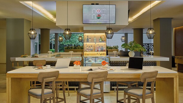 A modern dining area with a central island, bar, and seating. - Fiesta Inn Monterrey Valle (San Pedro Garza García)