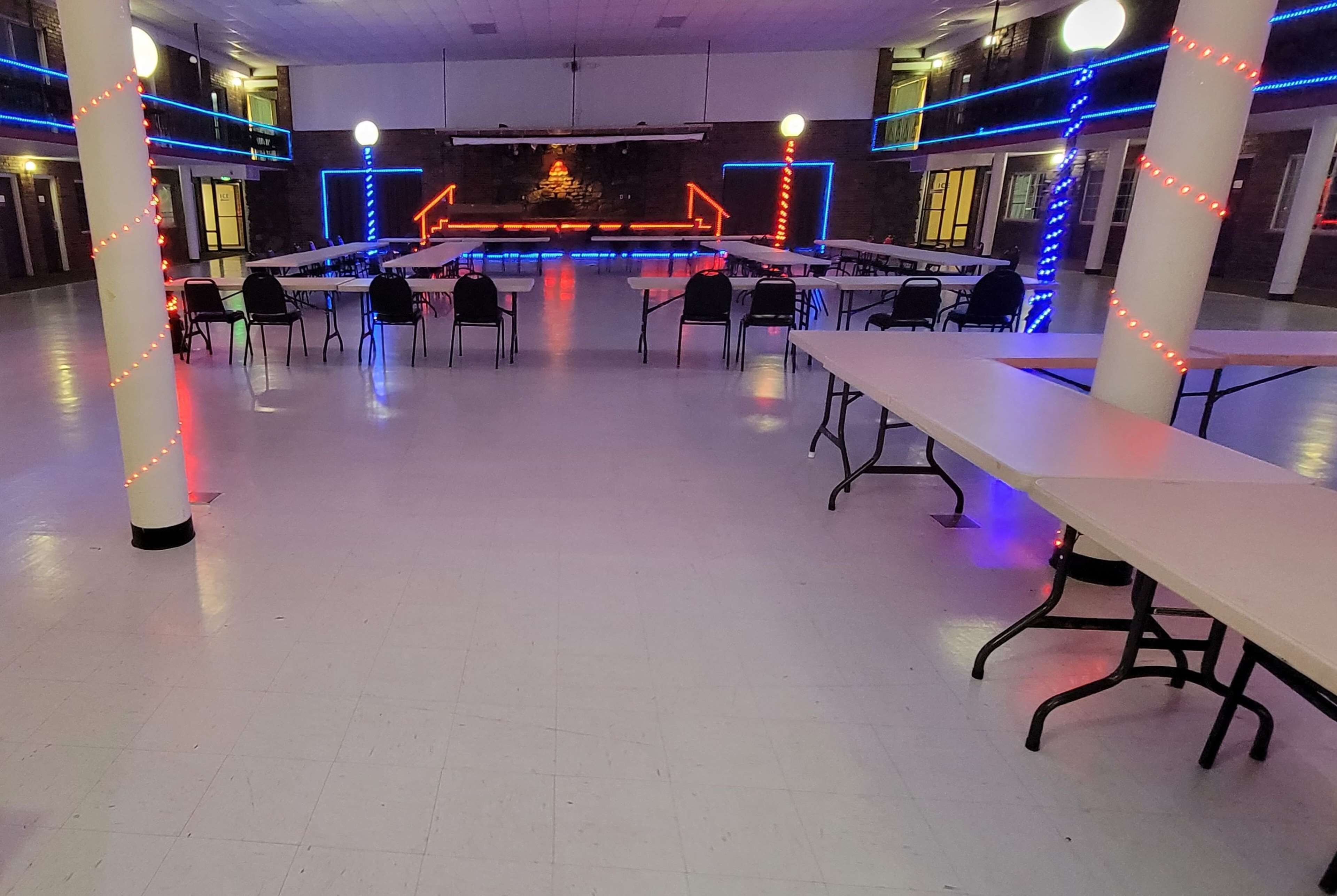 A spacious indoor area with tables and chairs arranged for dining or meetings.