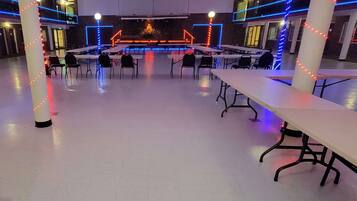 A spacious indoor area with tables and chairs arranged for dining or meetings.