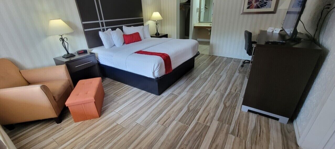 Ein Hotelzimmer mit Bett, Schreibtisch, Stuhl und einem kleinen Tisch.
