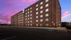 Um hotel com vários andares, fachada de tijolo e inúmeras janelas.