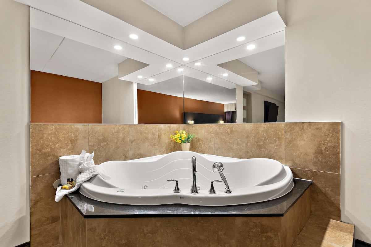 Un baño moderno con una bañera independiente, tocador y espejo.