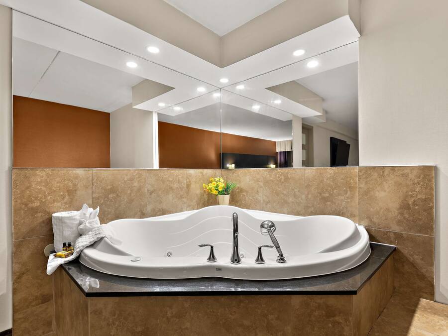 Un baño moderno con una bañera independiente, tocador y espejo.