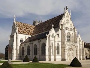 Um edifício grande e histórico, com uma entrada imponente, janelas em arco e telhado padronizado.
