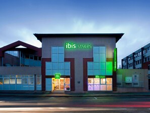 A building with a modern facade, large windows, and signage for 'ibis Styles'.