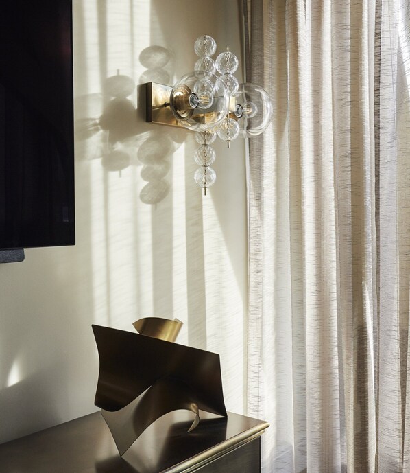 A modern interior with a wall-mounted light fixture and a geometric sculpture on a dark surface. - De L'Europe Amsterdam (Amsterdam)