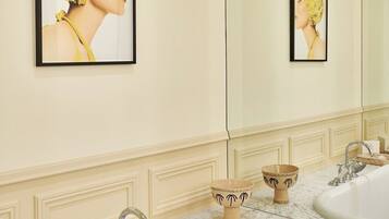 Un baño con dos lavamanos, un espejo grande y obras de arte enmarcadas en la pared.