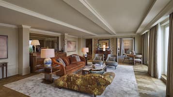 Ein großzügiges Wohnzimmer mit einer großen Couch, Sesseln und einem Couchtisch. Im Hintergrund ist eine Essecke mit Tisch und Stühlen zu sehen.