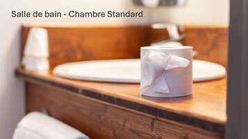 A bathroom with a wooden vanity, a white sink, and a tissue box.