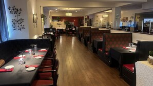 Un restaurante con cabinas y mesas, suelo de madera y un diseño interior moderno.