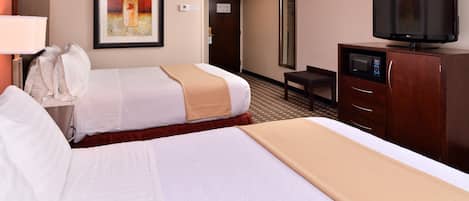 Quarto de hotel com duas camas, televisão, micro-ondas e secretária.