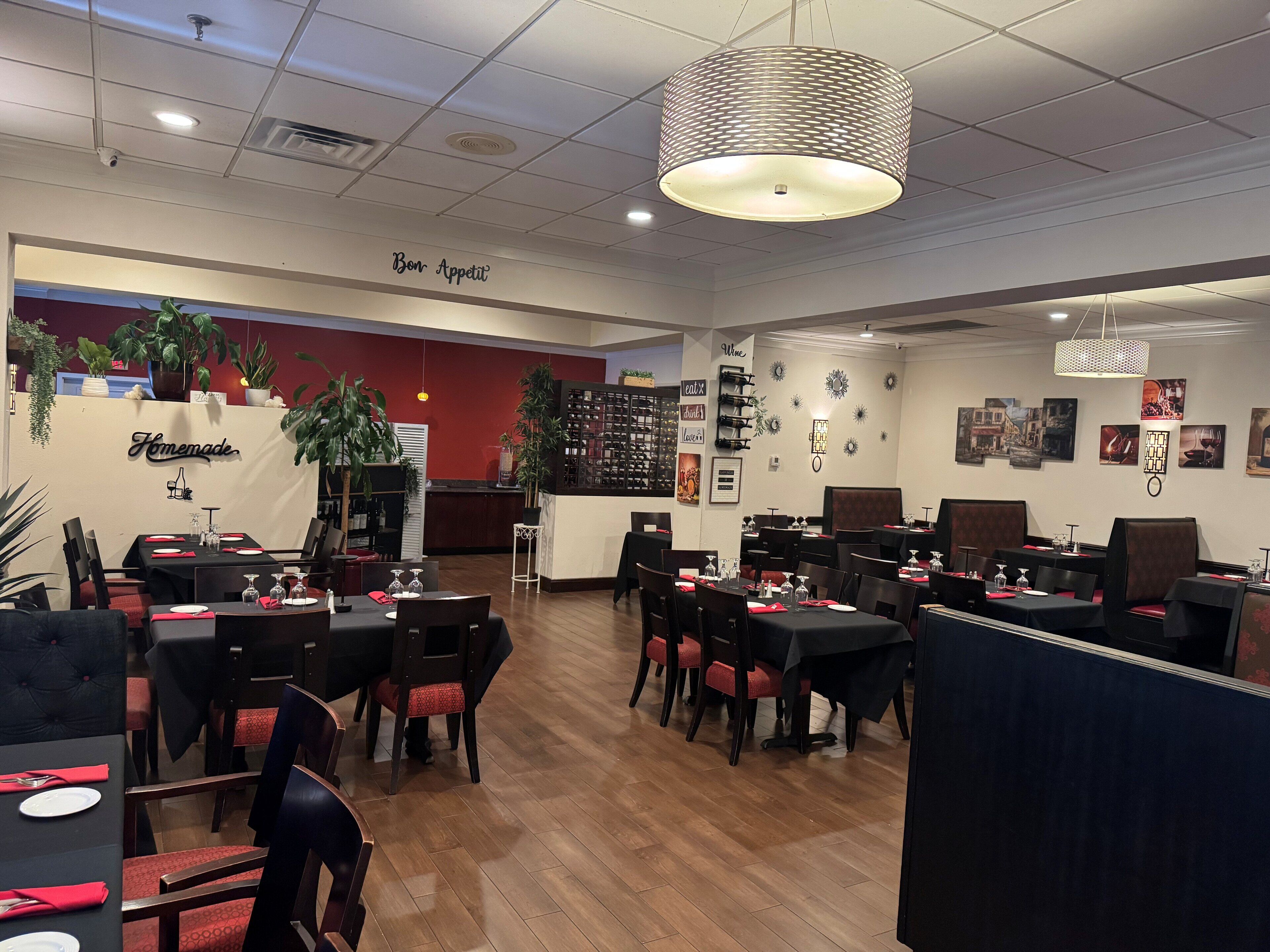 A restaurant interior with multiple dining tables, chairs, and a bar area.
