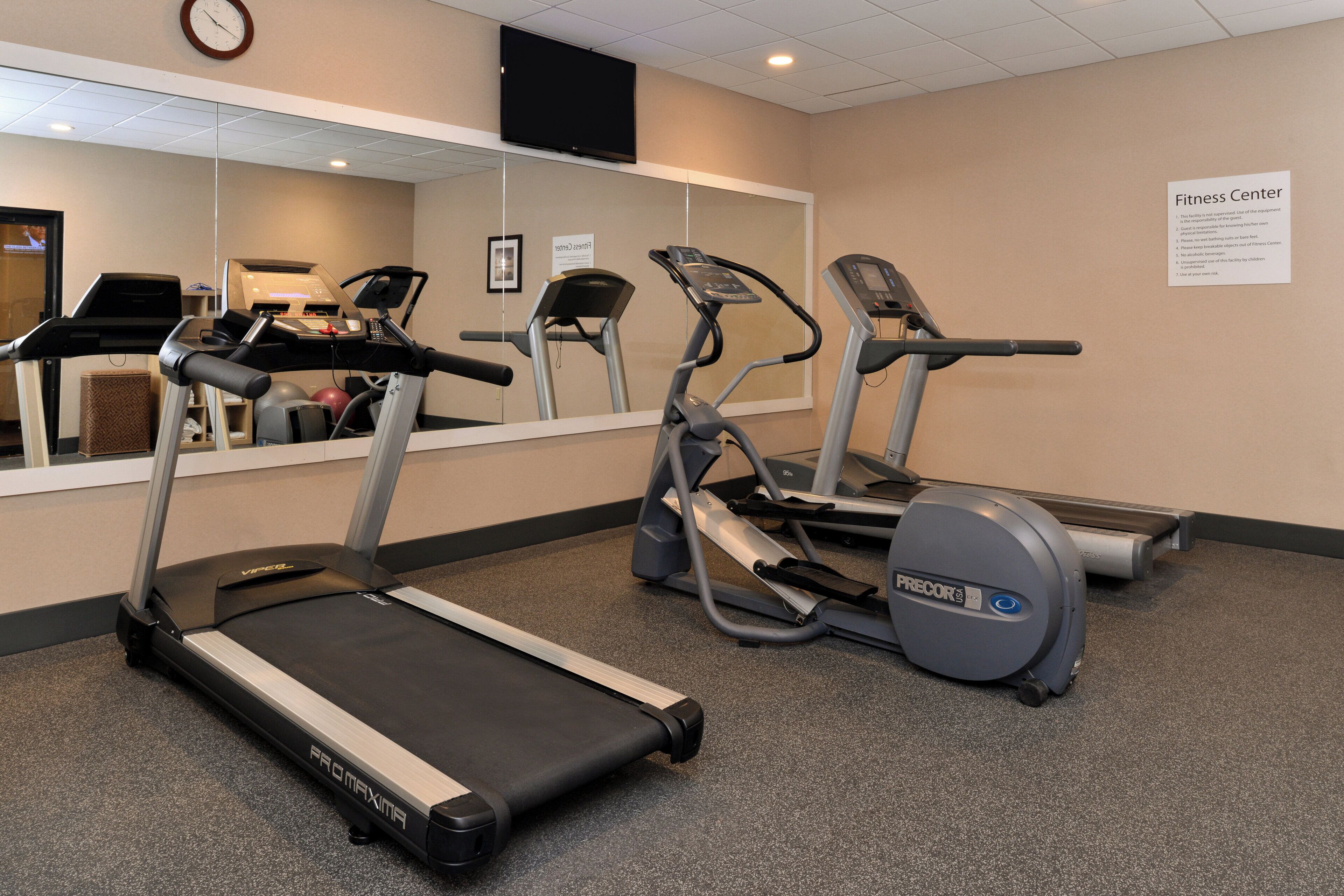 A fitness center with treadmills and elliptical machines.