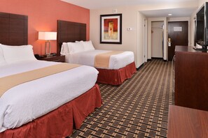 A hotel room with two beds, a desk, a TV, and a patterned carpet. - Holiday Inn New London - Mystic Area by IHG (New London)
