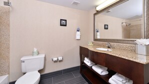 Un baño moderno con inodoro, lavamanos y espejo.