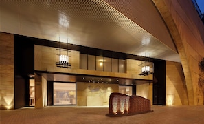 A modern building with a wooden facade, large windows, and a prominent sculpture in the foreground. - Park Hyatt Sydney (The Rocks)