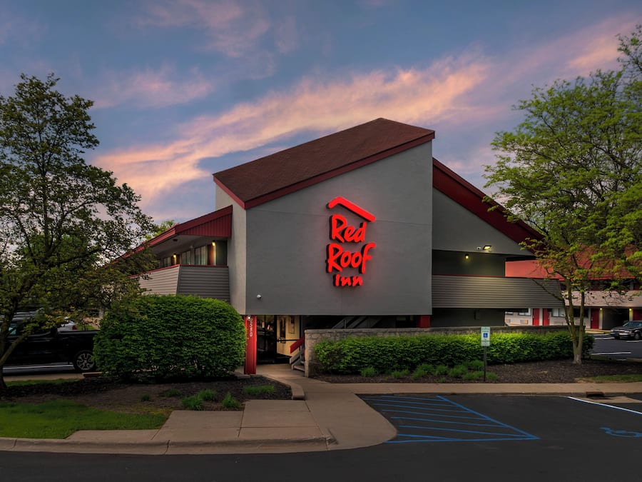A Red Roof Inn with a modern architectural design, featuring a prominent red roof and signage.